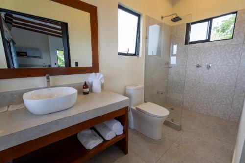 a bathroom with a sink and a toilet and a shower at Cabañas Vista Verde opción con jacuzzi in San Vito