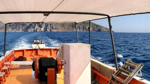 a boat in the ocean with a mountain in the background at Borgo Maria Rosa in San Salvatore di Fitalia