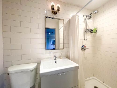 une salle de bain avec un lavabo, des toilettes et un miroir dans l'établissement Private Guesthouse North Sandpoint, à Seattle