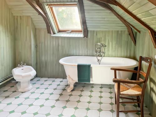 un bagno con vasca e WC di Maison Auvergnate à côté de Salers - 4 chambres - parking, garage - jardin - salle de jeux a Drugeac