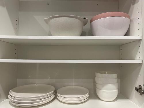 a white cabinet with bowls and plates in it at Executive Home in Windsor close to the airport in Windsor