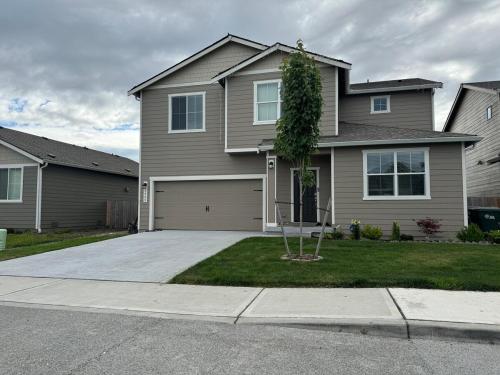 a house with a tree in front of a driveway at Utopia Luxury Stay - North Puyallup in Puyallup