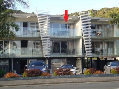 a building with cars parked in front of it at Paihia Beachfront 1 Bedroom Aptm in Paihia
