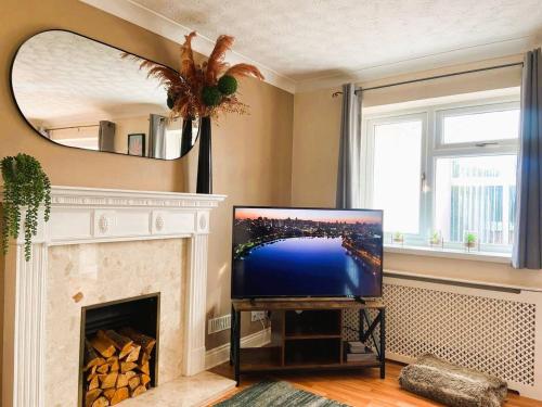 a living room with a tv and a fireplace at Large detached House in ELY with FREE private parking in Ely