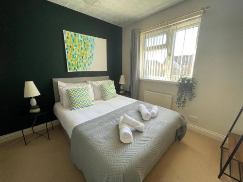 a bedroom with a large bed with towels on it at Large detached House in ELY with FREE private parking in Ely