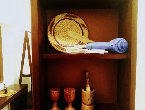 a wooden shelf with a plate and utensils on it at Bilin Villa in Ahangama