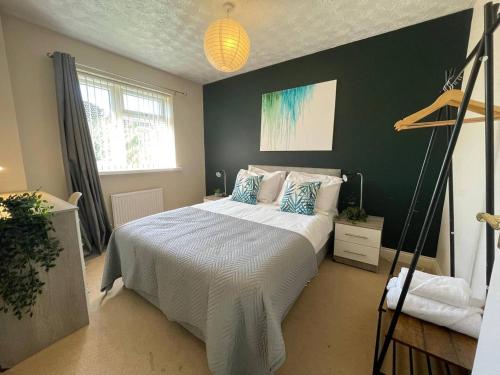 a bedroom with a bed and a green wall at Large detached House in ELY with FREE private parking in Ely