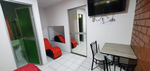 a bathroom with a toilet and a table and chairs at Hospedaje El Paraiso in Santa Eulalia