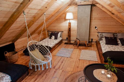 a living room with a hammock in a attic at BESKID NISKI Dębowy Przysiółek pod Cieklinką - Siedlisko na wyłączność DWA DOMKI in Cieklin