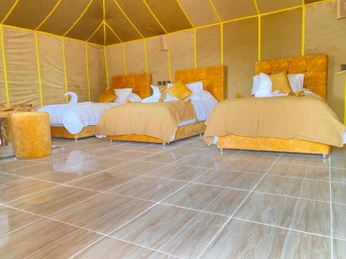 a room with two beds in a tent at Khadija Desert Camp in Merzouga