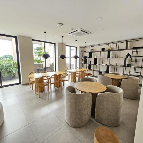 a restaurant with wooden tables and chairs and windows at LAFAYETTE by MrW in Guadalajara
