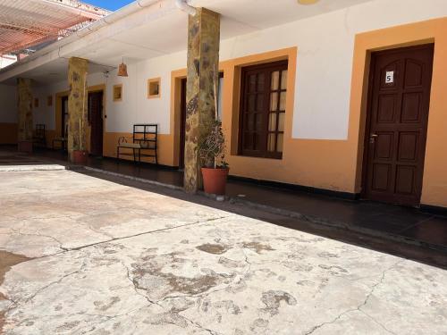 an empty courtyard of a building with doors at La Churita 2 - EL GUALICHO HOSTAL in Humahuaca