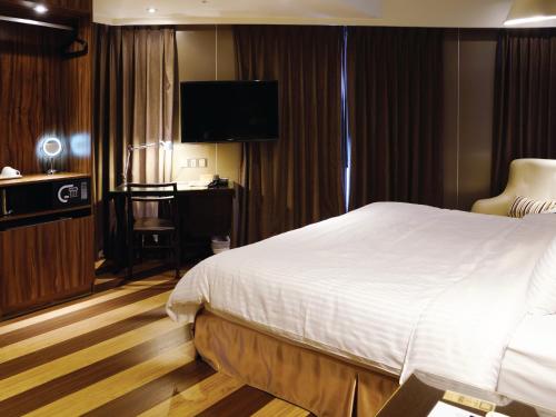 a hotel room with a bed and a television at Hotel Relax I in Taipei