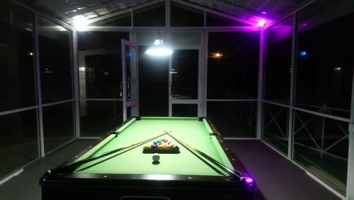 a pool table in a room with purple lights at Mount Edge Riverside Hotel in Bandarawela