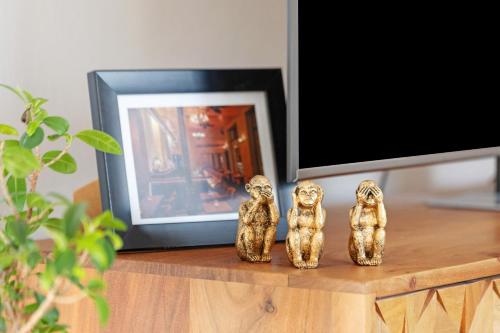 three small figurines sitting on a table next to a tv at Privatzimmer beim Gastgeber in Düsseldorf