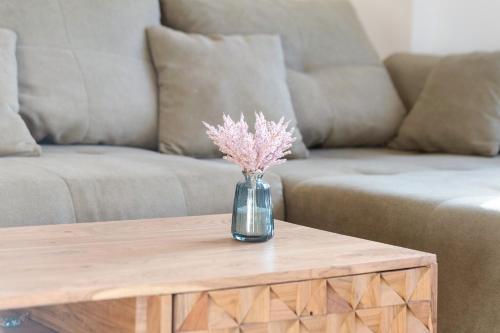 a vase of flowers on a coffee table in front of a couch at Privatzimmer beim Gastgeber in Düsseldorf