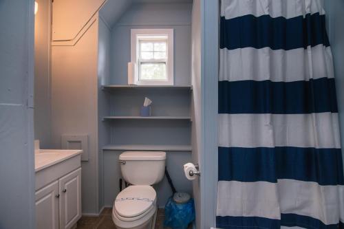 a bathroom with a toilet and a shower curtain at Misty Lane in Edisto Island