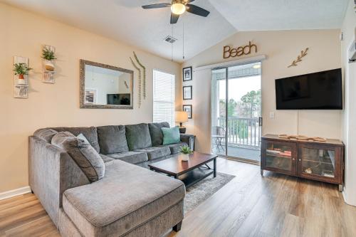 a living room with a couch and a tv at 4 Mi to Ocean Breezy Golf Condo in Myrtle Beach! in Myrtle Beach