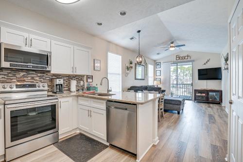 a kitchen with white cabinets and a stove top oven at 4 Mi to Ocean Breezy Golf Condo in Myrtle Beach! in Myrtle Beach