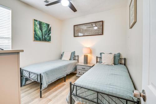 two beds in a room with white walls at 4 Mi to Ocean Breezy Golf Condo in Myrtle Beach! in Myrtle Beach