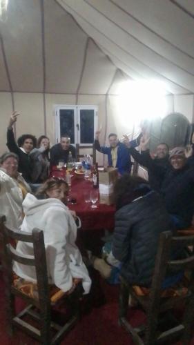 a group of people sitting around a table in a tent at Khadija Desert Camp in Merzouga