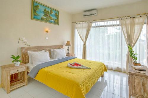 a bedroom with a bed with a yellow bedspread at Villa Chandra in Seminyak