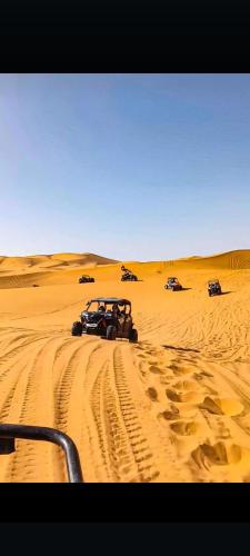 a vehicle driving in the sand in the desert at Khadija Desert Camp in Merzouga