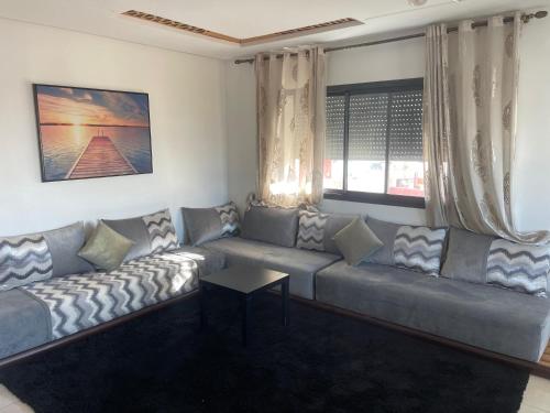 a living room with a couch and a table at Votre Repaire Calme, Confort et Convivialité in Kenitra