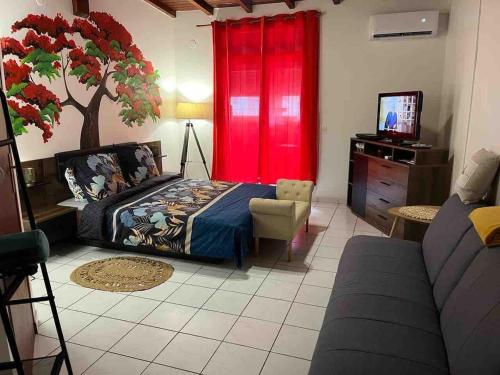 a bedroom with a bed and a tree on the wall at Poupeye in Sainte-Anne