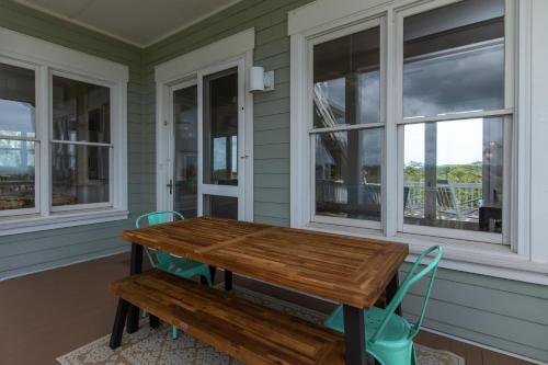a porch with a wooden table and two windows at Tequila Sunset in Edisto Island