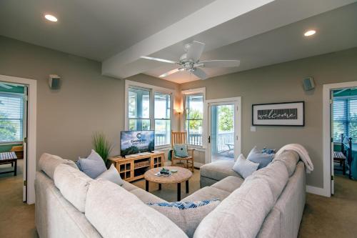 a living room with a large couch and a ceiling fan at Tequila Sunset in Edisto Island