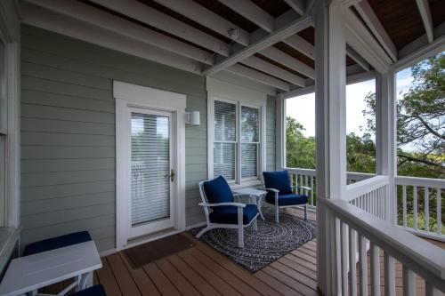 a porch with two chairs and a table on it at Tequila Sunset in Edisto Island