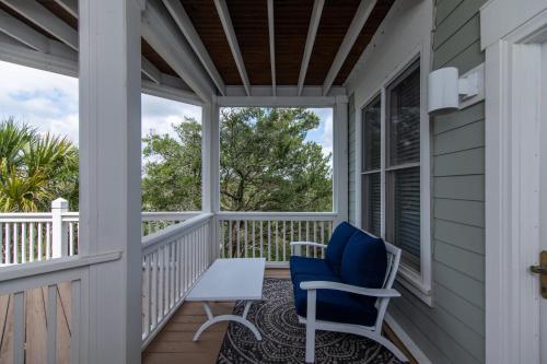 a porch with a blue chair and a table at Tequila Sunset in Edisto Island