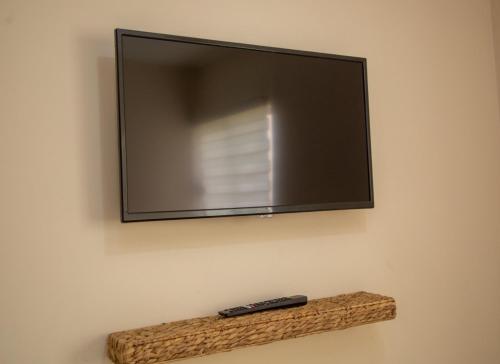 ein Fernseher an einer Wand mit einer Fernbedienung auf einem Regal in der Unterkunft Departamento Nuevo en Hermosillo in Hermosillo