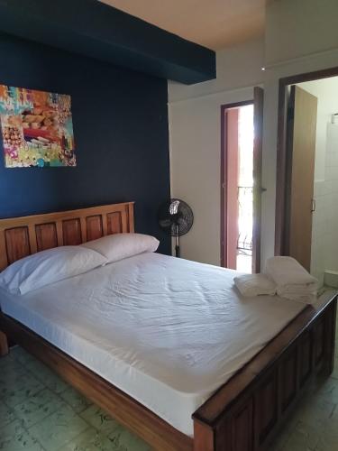a bedroom with a large bed with a blue wall at Panamá Hostels Inn in David