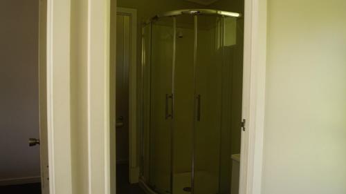 a shower with a glass door in a bathroom at Apple Motor Inn in Hastings