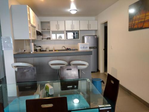 a kitchen with a glass table and two stools at Dpto en Paracas con vista al Mar in Paracas