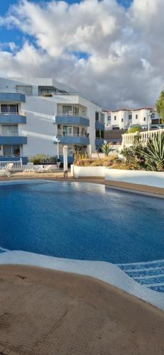 een groot zwembad voor een gebouw bij Relax flat palm view in San Miguel de Abona