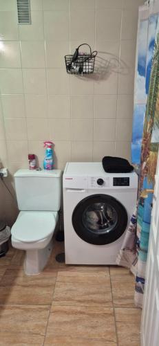 een badkamer met wasmachine en toilet bij Relax flat palm view in San Miguel de Abona