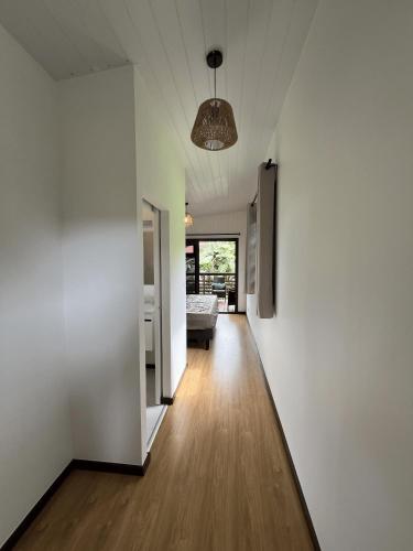 a hallway of a house with white walls and wooden floors at Hava'i Lodge in Taputapuapea