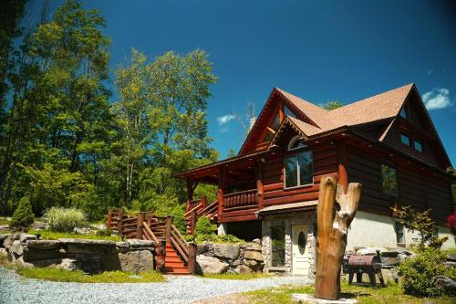 a large log cabin with a porch at Cozy Catskill Log Home in Monticello