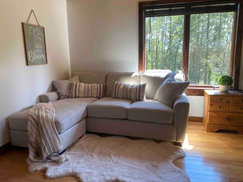 a living room with a couch and a window at Cozy Catskill Log Home in Monticello
