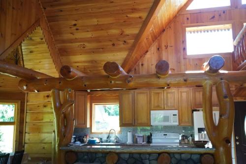 a kitchen with wooden walls and a wooden ceiling at Cozy Catskill Log Home in Monticello