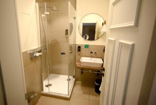 a bathroom with a shower and a sink and a mirror at Hotel Gelber Löwe Großhabersdorf in Großhabersdorf