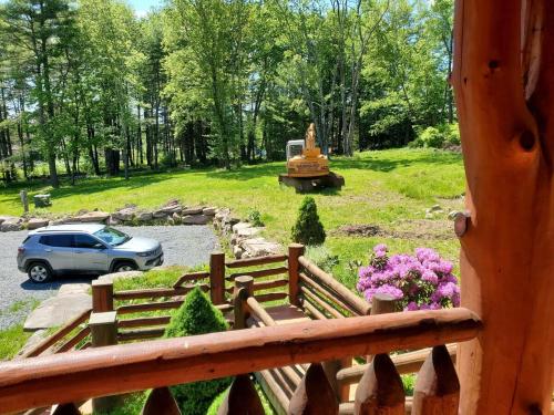 a car parked in a parking lot next to a wooden fence at Cozy Catskill Log Home in Monticello