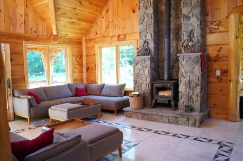 a living room with a couch and a fireplace at Cozy Catskill Log Home in Monticello