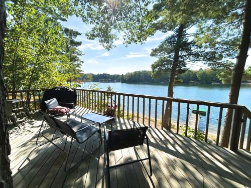 a table and chairs on a deck with a view of a lake at Lakefront Hot Tub Getaway in Traverse City