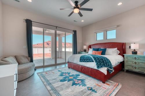 Schlafzimmer mit einem roten Bett und einem Deckenventilator in der Unterkunft Lux Kanab Home with Pool Hot Tub Pickleball Courts in Kanab