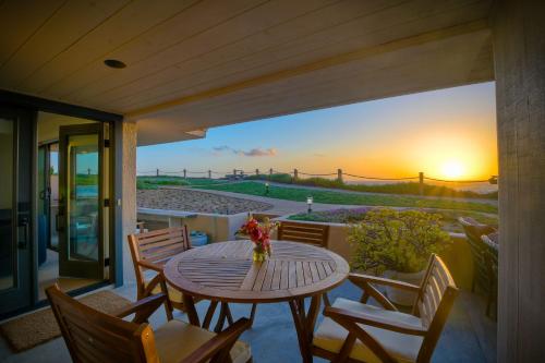 a table and chairs on a balcony with a sunset at 597 S Sierra Avenue - Unit 68 in Solana Beach