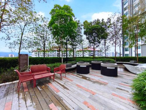 un parco con una panchina rossa e due sedie di Cozy HomeBit a Kuala Lumpur